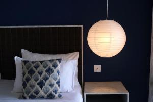 a bedroom with a bed with a lamp and a table at BeachMirissa Hotel in Mirissa