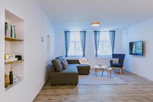 a living room with a couch and two windows at Chalupa Na Rachačkách in Kamenice nad Lipou