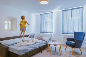 a young child jumping on a bed in a room at Chalupa Na Rachačkách in Kamenice nad Lipou