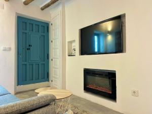 a living room with a fireplace and a flat screen tv at CASA MÚA in Frigiliana