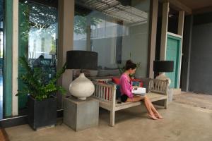 a woman sitting on a bench reading a book at BeachMirissa Hotel in Mirissa