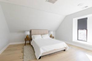 een witte slaapkamer met een bed en een raam bij Denver Haven with Rocky Mountain Views in Denver
