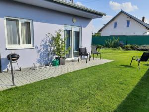 a patio with chairs and a grill in a yard at Modrý apartmán 1 in Znojmo