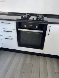 a kitchen with a black stove and white cabinets at Villa privé 4 chambres 4 lit double à Djerba en face de la ferme de lotos in Midoun