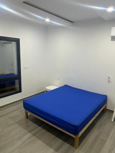 ein großes blaues Bett in einem Zimmer mit Fenster in der Unterkunft Villa privé 4 chambres 4 lit double à Djerba en face de la ferme de lotos in Midoun