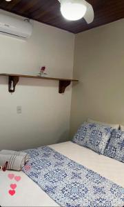 a bedroom with a bed and a shelf on the wall at Recanto da Bruna in Abraão