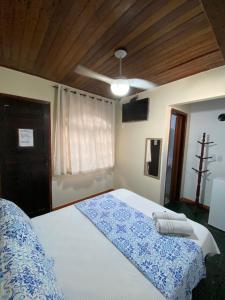 a bedroom with a large white bed with a ceiling at Recanto da Bruna in Abraão