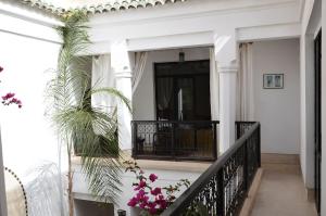 a white house with a balcony and plants at Riad Rouge Gorge in Marrakesh