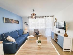 a living room with a blue couch and a tv at Optimist las americas in Playa de las Americas