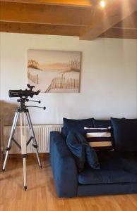una cámara en un trípode en una sala de estar con sofá en Sea View B & B, en Ulsta