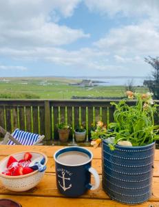 een tafel met twee kopjes koffie en een kom tomaten bij Sea View B & B in Ulsta