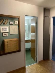 un couloir avec un miroir et une salle de bains avec un lavabo dans l'établissement Best views and location in Leukerbad!, à Loèche-les-Bains