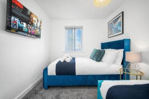 a bedroom with two beds and a blue headboard at Contractors & Families Delight - Spacious 3-Bed Accommodation Sleeps 7, Snooker Table, Smart TV, Netflix, Parking, Derby City Centre in Derby
