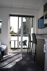 a room with a bed and a kitchen with a balcony at ApartHotel Faber in Aarhus