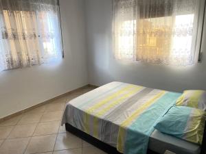 um pequeno quarto com uma cama e 2 janelas em Azur em Oued Laou