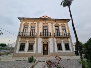 uma casa velha com uma palmeira em frente em Palace Hotel de Midões em Midões