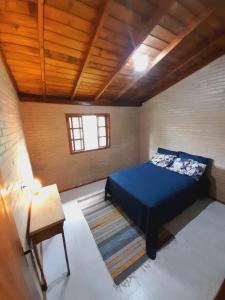 加羅帕巴的住宿－Casa da Cachoeira Siriú-SC，一间卧室设有蓝色的床和木制天花板