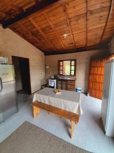una grande cucina con tavolo e frigorifero di Casa da Cachoeira Siriú-SC a Garopaba