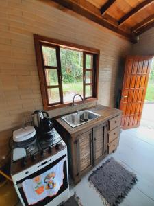 una cucina con piano cottura e lavandino di Casa da Cachoeira Siriú-SC a Garopaba
