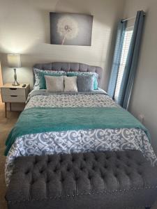 1 dormitorio con 1 cama grande y cabecero gris en Susan’s Place, en Deltona