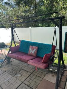 a swing with pillows on it on a patio at Susan’s Place in Deltona