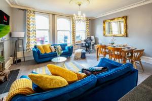 a living room with blue couches and a dining room at Stylish & Cosy 3bdr In Fulham with roof terrace in London