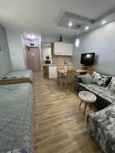 a living room with two beds and a kitchen at Apartmani Dušica Konaci Kopaonik in Kopaonik