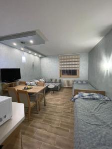 uma sala de estar com duas camas e uma mesa em Apartmani Dušica Konaci Kopaonik em Kopaonik