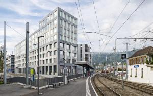 ein hohes Gebäude neben einem Bahnhof mit Gleisen in der Unterkunft Optimum Apartment - Wolframplatz in Zürich