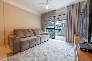 sala de estar con sofá y TV en 299 - Excelente apto com 03 dormitórios, a 100m da praia de Bombas, en Bombinhas