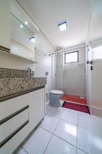 y baño con ducha, aseo y lavamanos. en 299 - Excelente apto com 03 dormitórios, a 100m da praia de Bombas, en Bombinhas