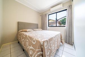 1 dormitorio con cama y ventana en 299 - Excelente apto com 03 dormitórios, a 100m da praia de Bombas, en Bombinhas