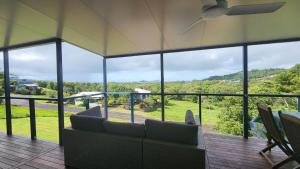 Una sala de estar con un sofá y una ventana grande. en Bedarra Beachhouse, en South Mission Beach