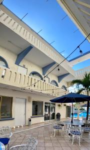 a patio with tables and chairs and an umbrella at Hotel Playa de Oro - Enfrente de WTC y Plazas Comerciales in Veracruz