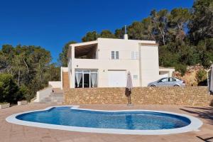 a villa with a swimming pool in front of a house at beautiful views with pool in ibiza in Sant Miquel de Balansat