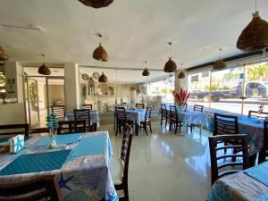 un restaurante con mesas y sillas azules y ventanas en Hotel Playa de Oro - Enfrente de WTC y Plazas Comerciales en Veracruz