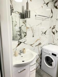 łazienka z umywalką i pralką w obiekcie New Classic Górne w mieście Piła