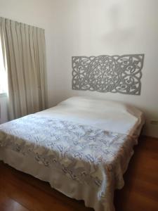 1 dormitorio con 1 cama con colcha en blanco y negro en Temporarios Alto Verde en Córdoba