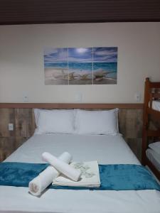 een slaapkamer met een bed met een handdoek erop bij Pousada Viva praia 30 metros da Praia in Penha