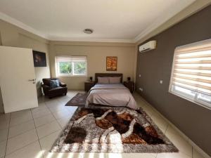 een slaapkamer met een bed en een tapijt op de vloer bij Discover Accra's Hidden Gem in Accra