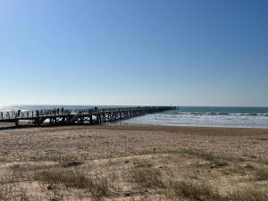 a pier on a beach next to the ocean at Studio - Pleine Mer - 1 avenue des Pays de Monts - 1-1 in Saint-Jean-de-Monts +8 photos