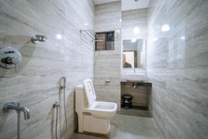 a bathroom with a toilet and a sink and a mirror at Darsy Residency and beach cottages in Agonda