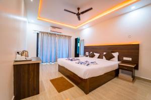 1 dormitorio con 1 cama grande y ventilador de techo en Darsy Residency en Agonda