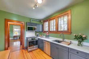 una cocina con paredes verdes y electrodomésticos de acero inoxidable en Near Downtown Cincinnati Peaceful Retreat!, en Blue Ash 17 fotos más