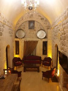a living room with a couch and a table and chairs at Mardin tarihi ulu Cami yanı, Kale divan konağı in Mardin