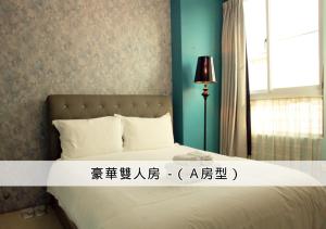 a bedroom with a bed with a sign on it at 在海的另一邊 in Anping