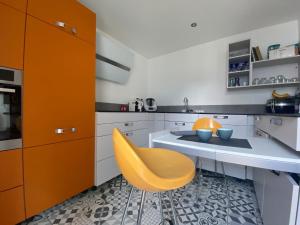 a kitchen with a table and a yellow chair at Appartement la défense Courbevoie in Courbevoie