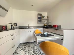 a kitchen with a table and a yellow chair at Appartement la défense Courbevoie in Courbevoie