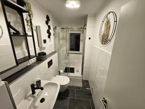a white bathroom with a sink and a toilet at Pohl Fewo in Remscheid