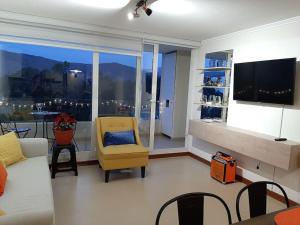 uma sala de estar com um sofá e uma cadeira amarela em Dpto 2D1B en Papudo Laguna, Piso 8, Edf Flemenco con vista al mar em Papudo